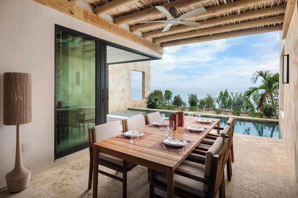 Covered patio dining beside the private pool at The Strand Turks and Caicos.