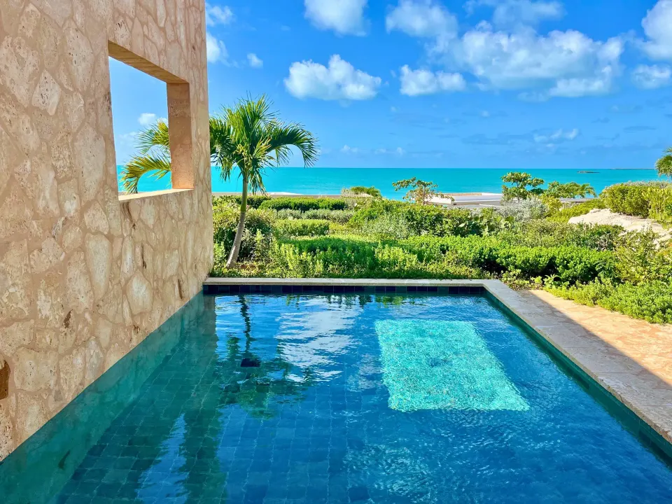 Private pool with turquoise ocean beyond at The Strand Turks and Caicos.