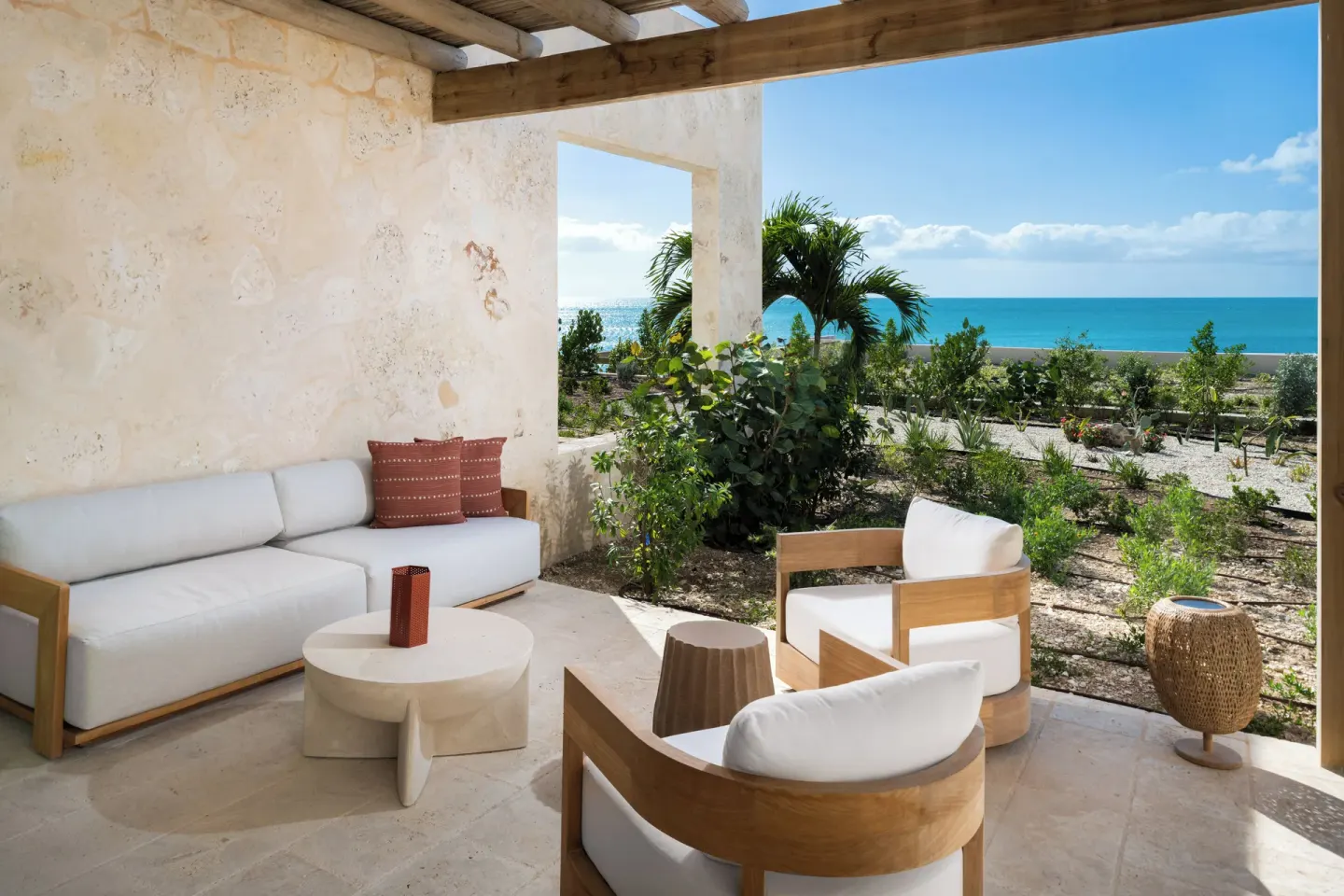 Covered patio seating with garden and ocean view at The Strand Turks and Caicos.