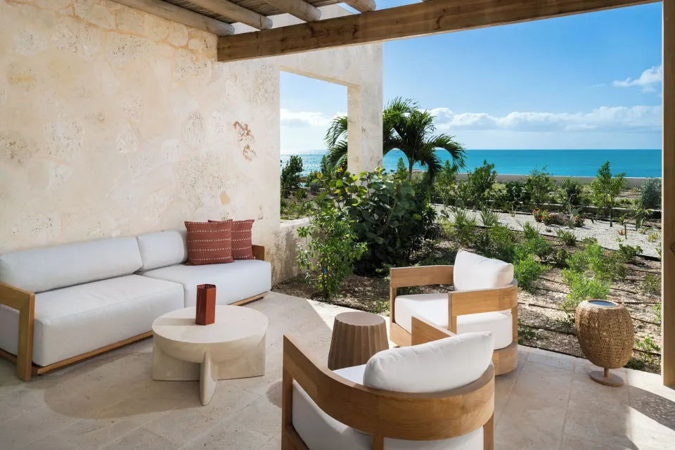 Covered patio seating with garden and ocean view at The Strand Turks and Caicos.