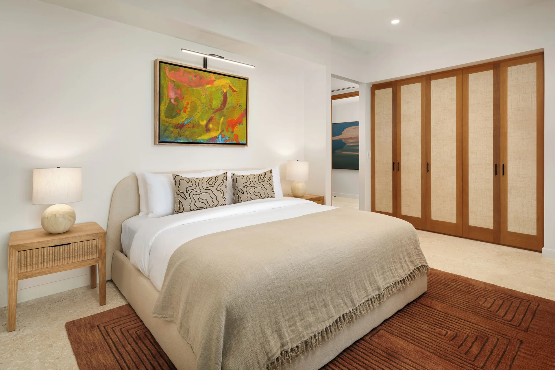 One-bedroom suite with king bed and wood wardrobes at The Strand Turks and Caicos.