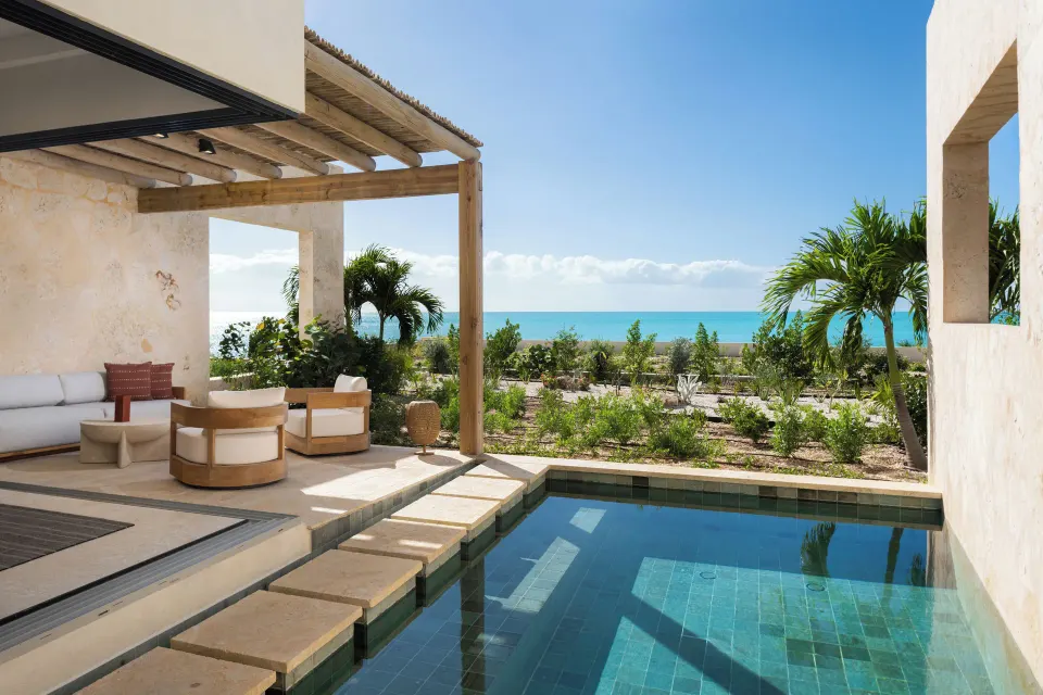 Suite plunge pool terrace with ocean beyond the garden at The Strand Turks and Caicos.