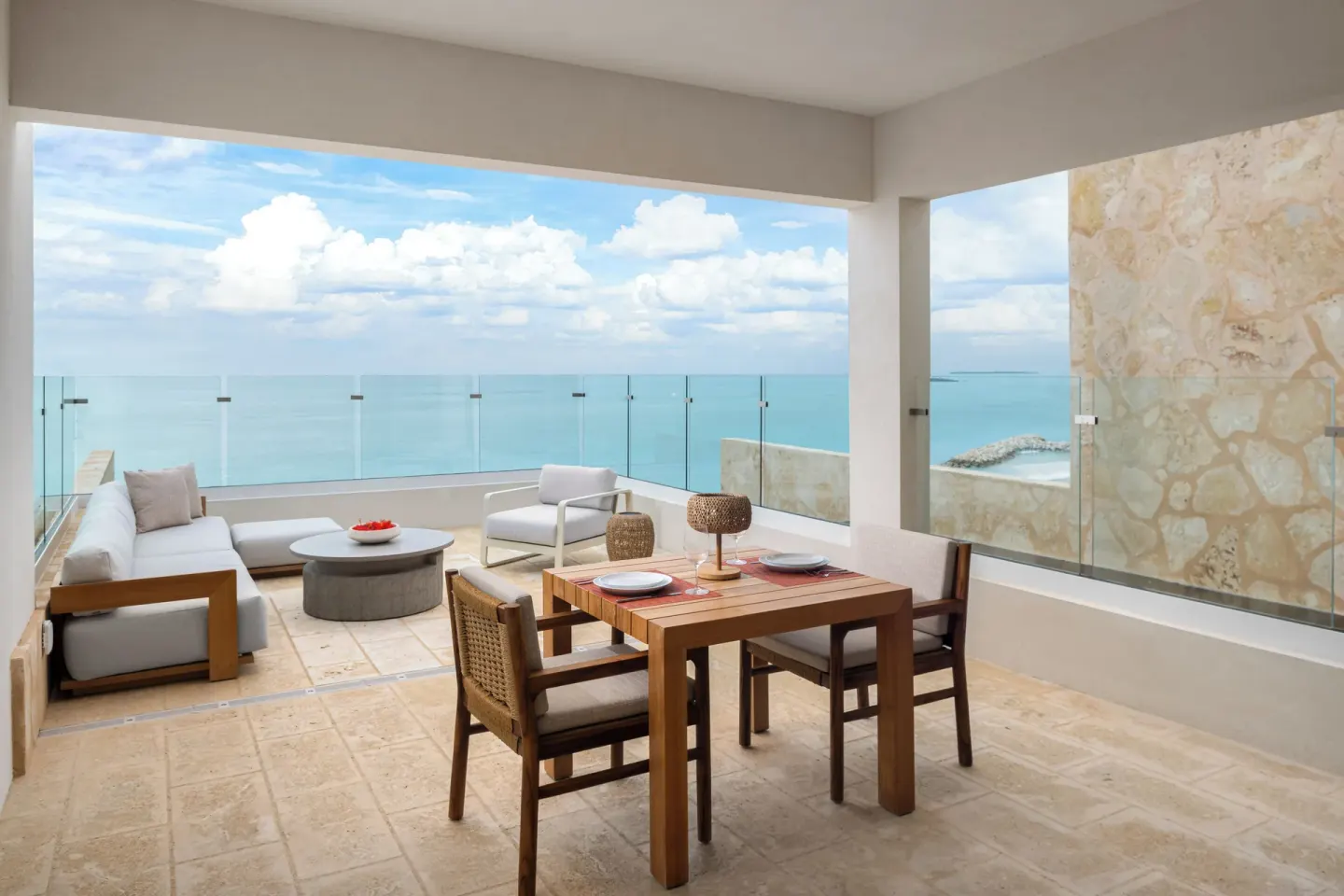 Second-floor suite terrace with seating, dining area and wide ocean view at The Strand Turks and Caicos.