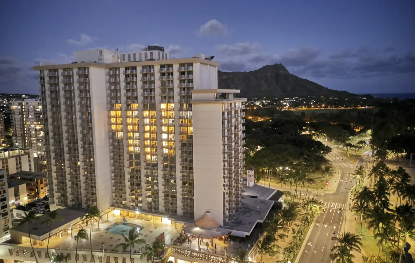 Evening exterior of The Twin Fin Hotel with Diamond Head in the background.