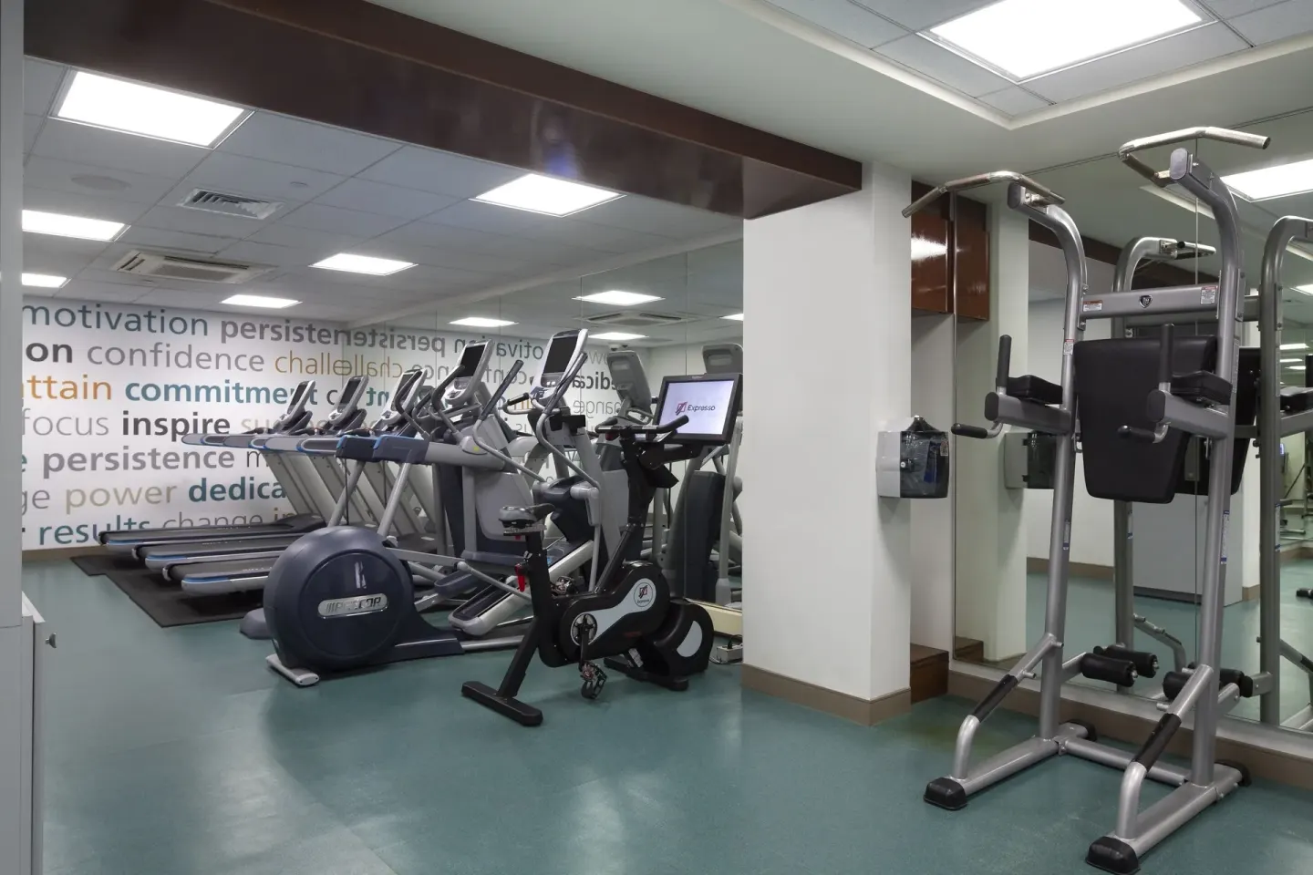 Fitness room with cardio equipment and a strength station at The Twin Fin Hotel.