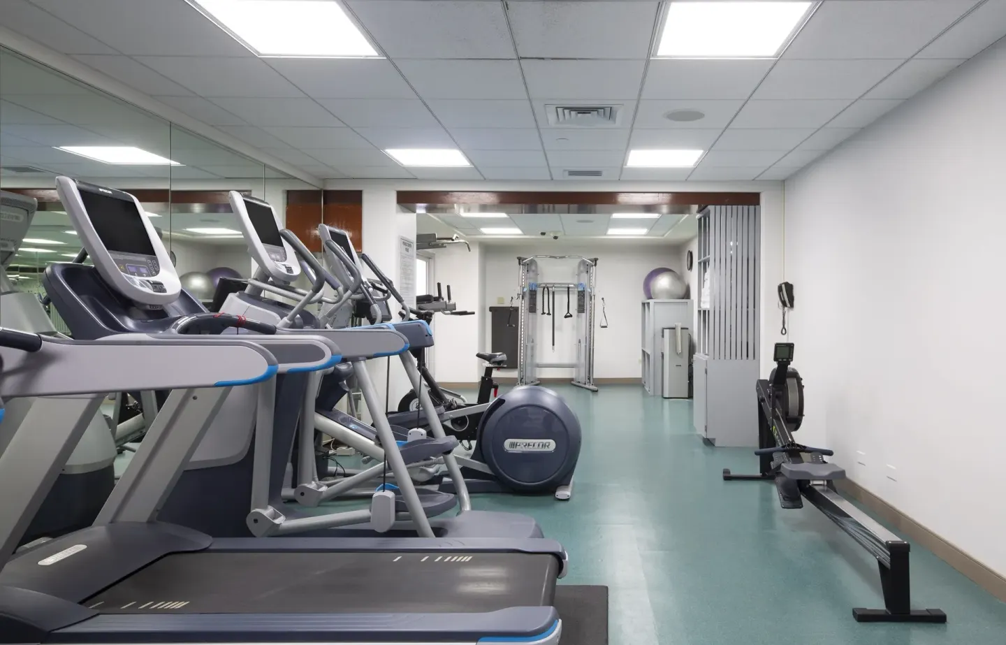 Cardio machines and a rowing machine in the fitness room at The Twin Fin Hotel.