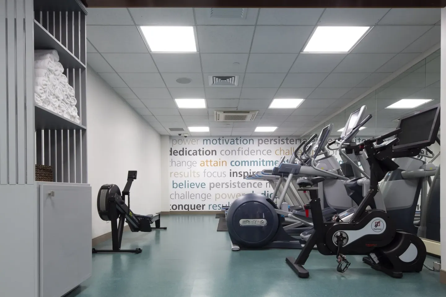 Exercise bikes, elliptical machines, and towels in the fitness room at The Twin Fin Hotel.