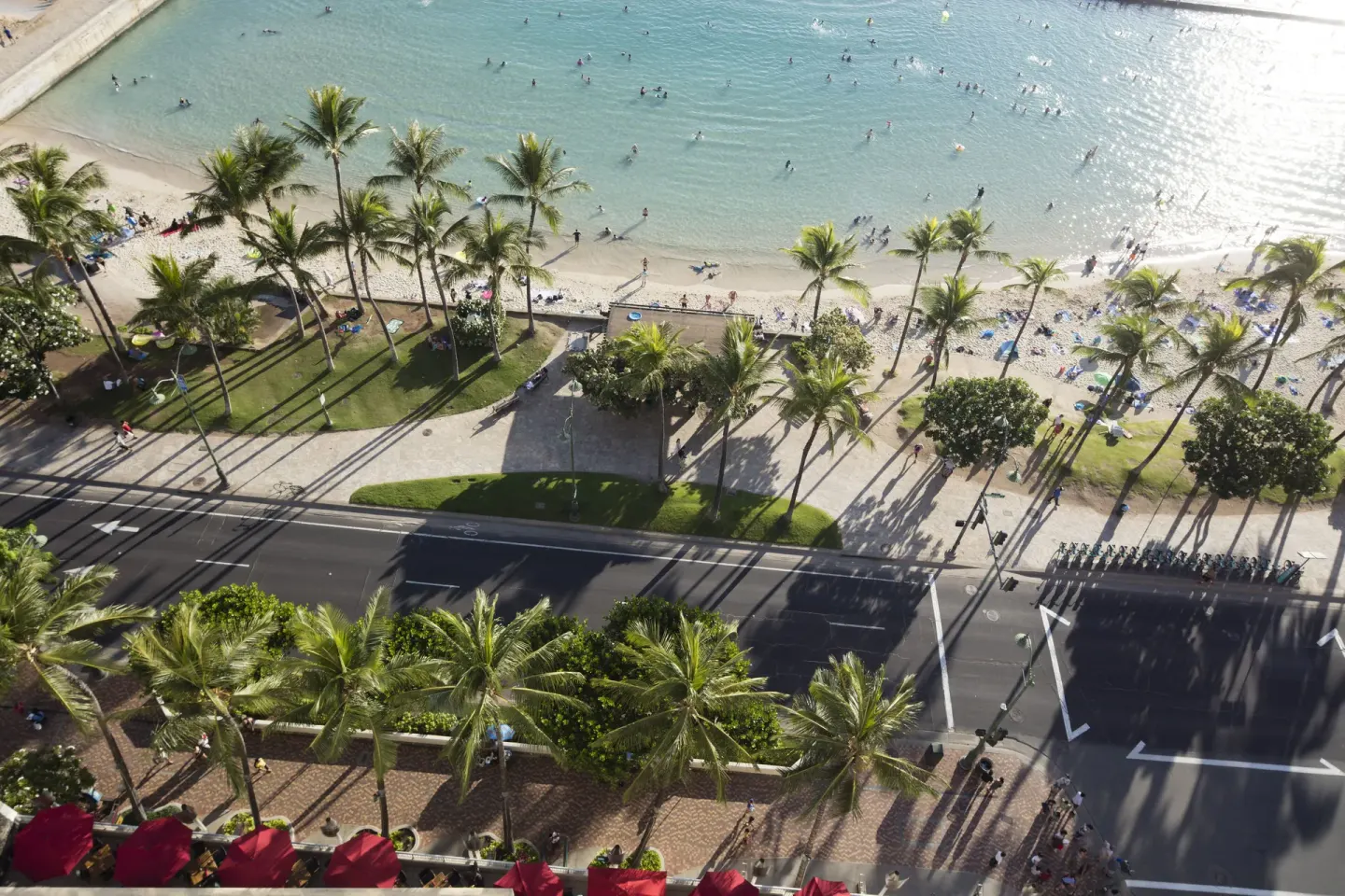 High view from The Twin Fin Hotel over Kalakaua Avenue, palms, beach, and ocean.