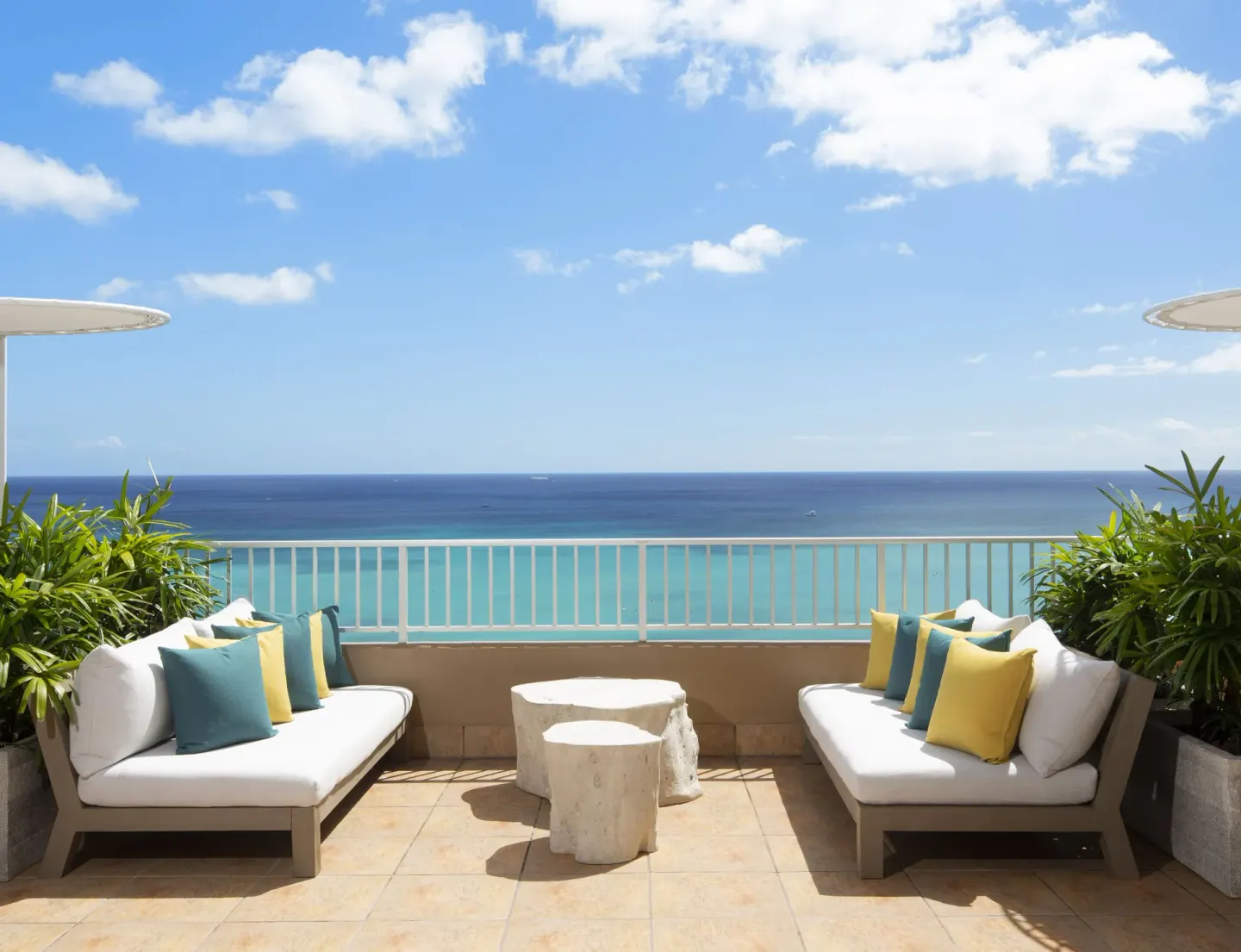Oceanfront terrace seating with colorful pillows at The Twin Fin Hotel.