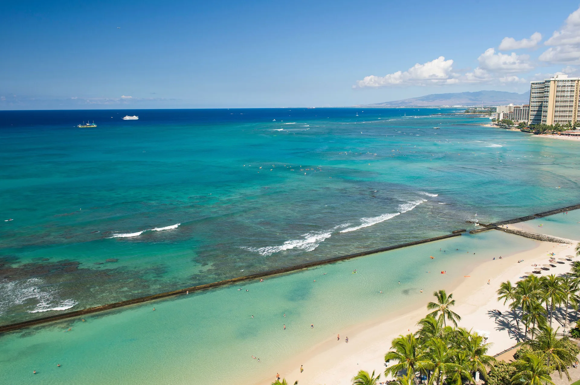 Aerial view of Waikiki Beach and turquoise ocean from The Twin Fin Hotel.