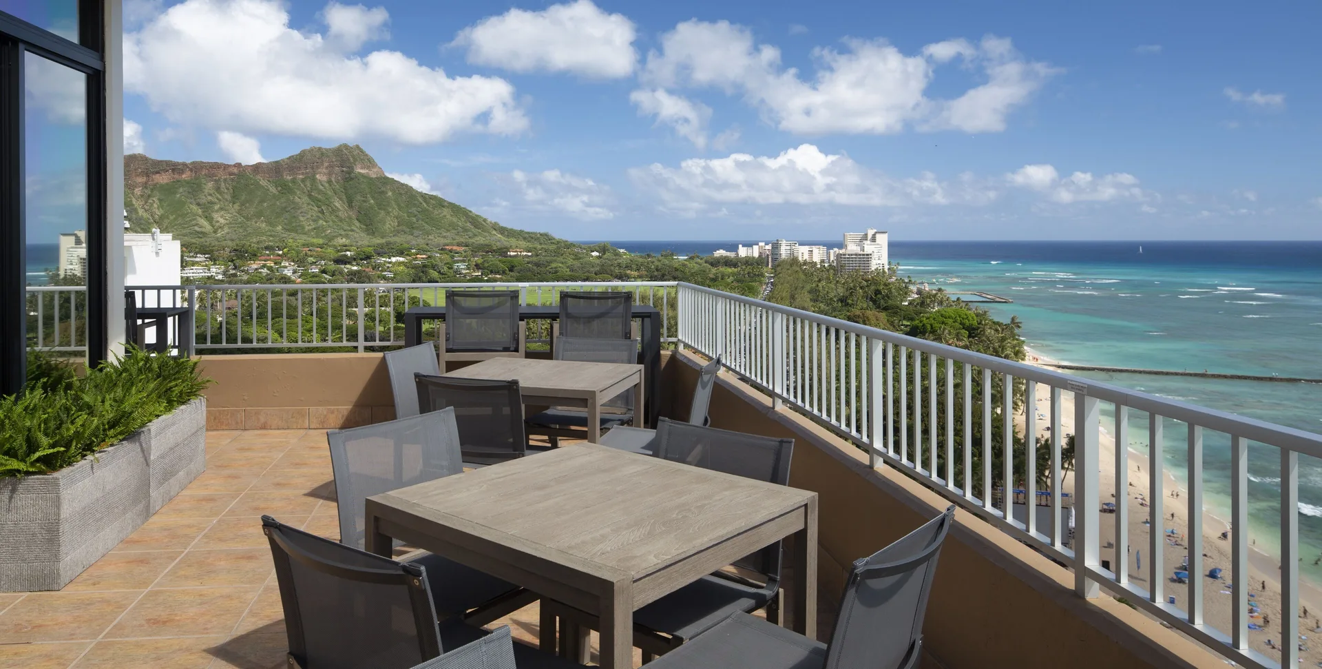 Terrace dining tables with Diamond Head and ocean views at The Twin Fin Hotel.