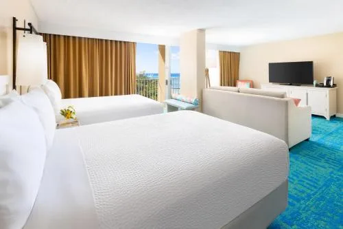 Aloha Suite Partial Ocean View with two beds and sitting area at The Twin Fin Hotel.