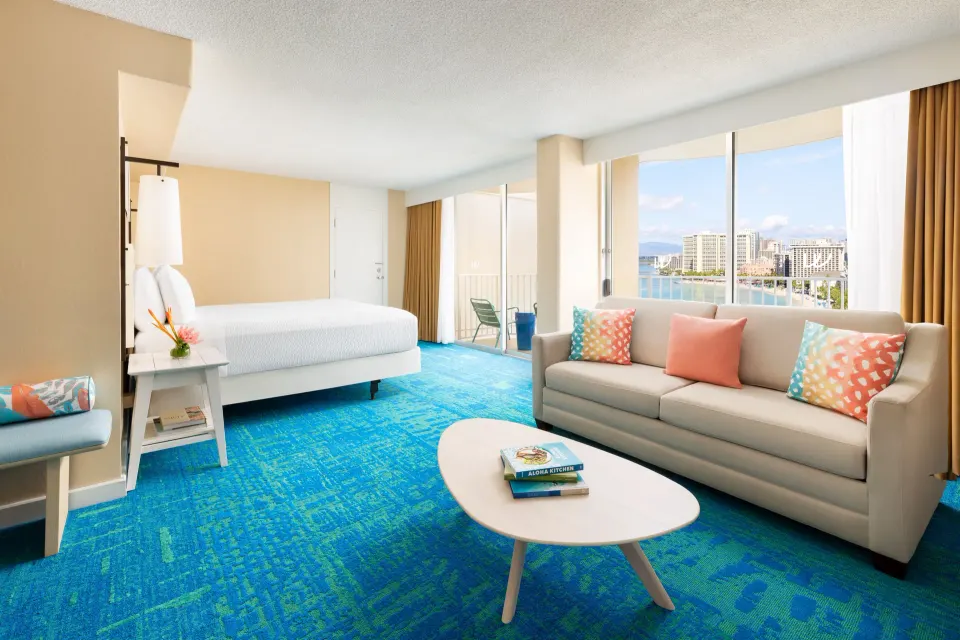 Junior Suite Ocean View at The Twin Fin Hotel with king bed, sofa, balcony, and shoreline view.