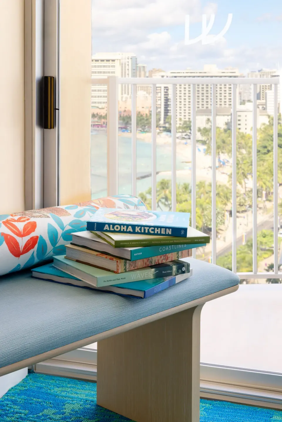 Window bench in a Junior Suite Ocean View at The Twin Fin Hotel with books and a beach view.