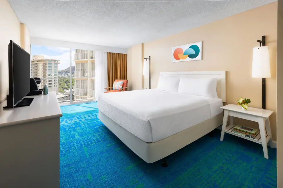 King bed, TV console, and city view window in a City View room at The Twin Fin Hotel.