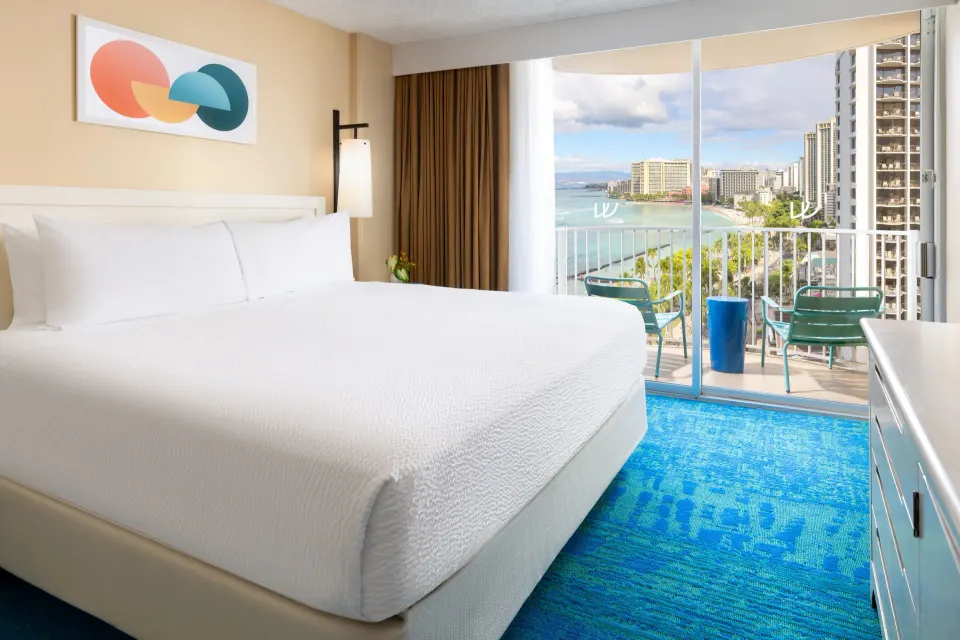 King bed ocean view room with balcony seating at The Twin Fin Hotel.
