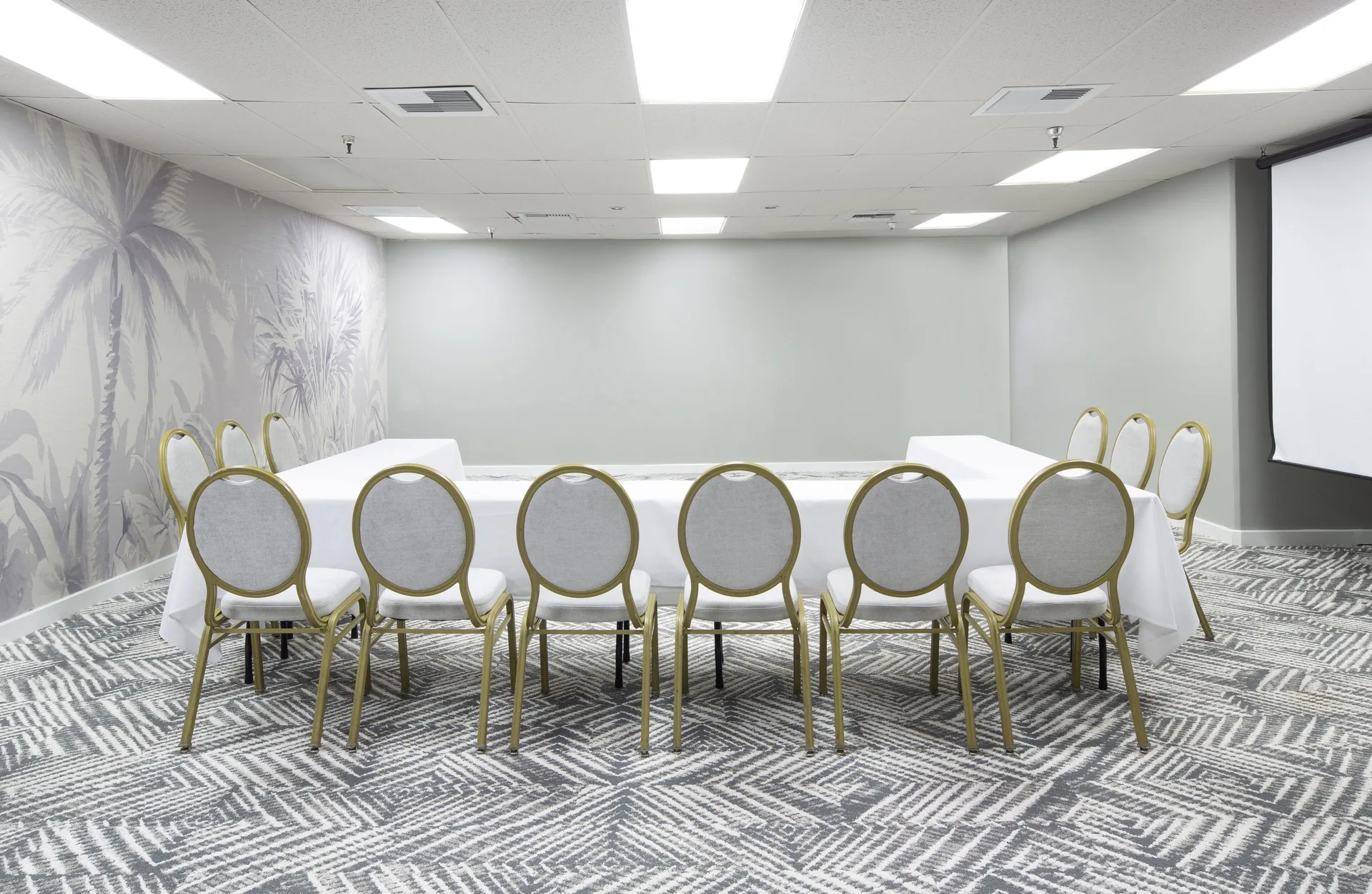 Conference room with a long table and projection screen at The Twin Fin Hotel.