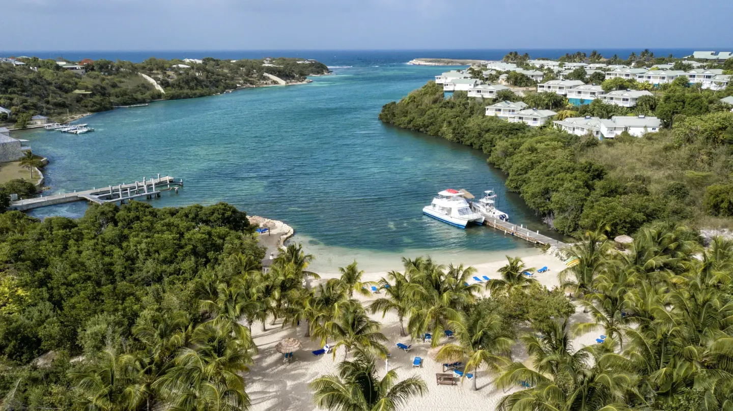 Aerial view of the cove, beach, dock, and hillside villas at The Verandah Antigua.