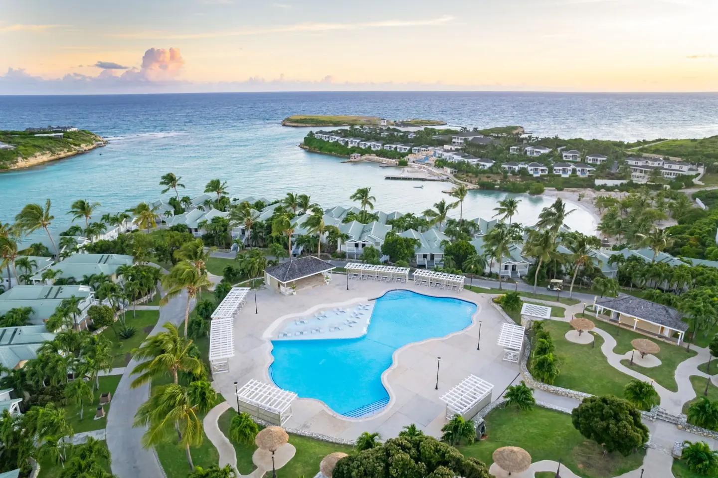 Aerial resort view with main pool, villas, bay, and ocean at The Verandah Antigua.