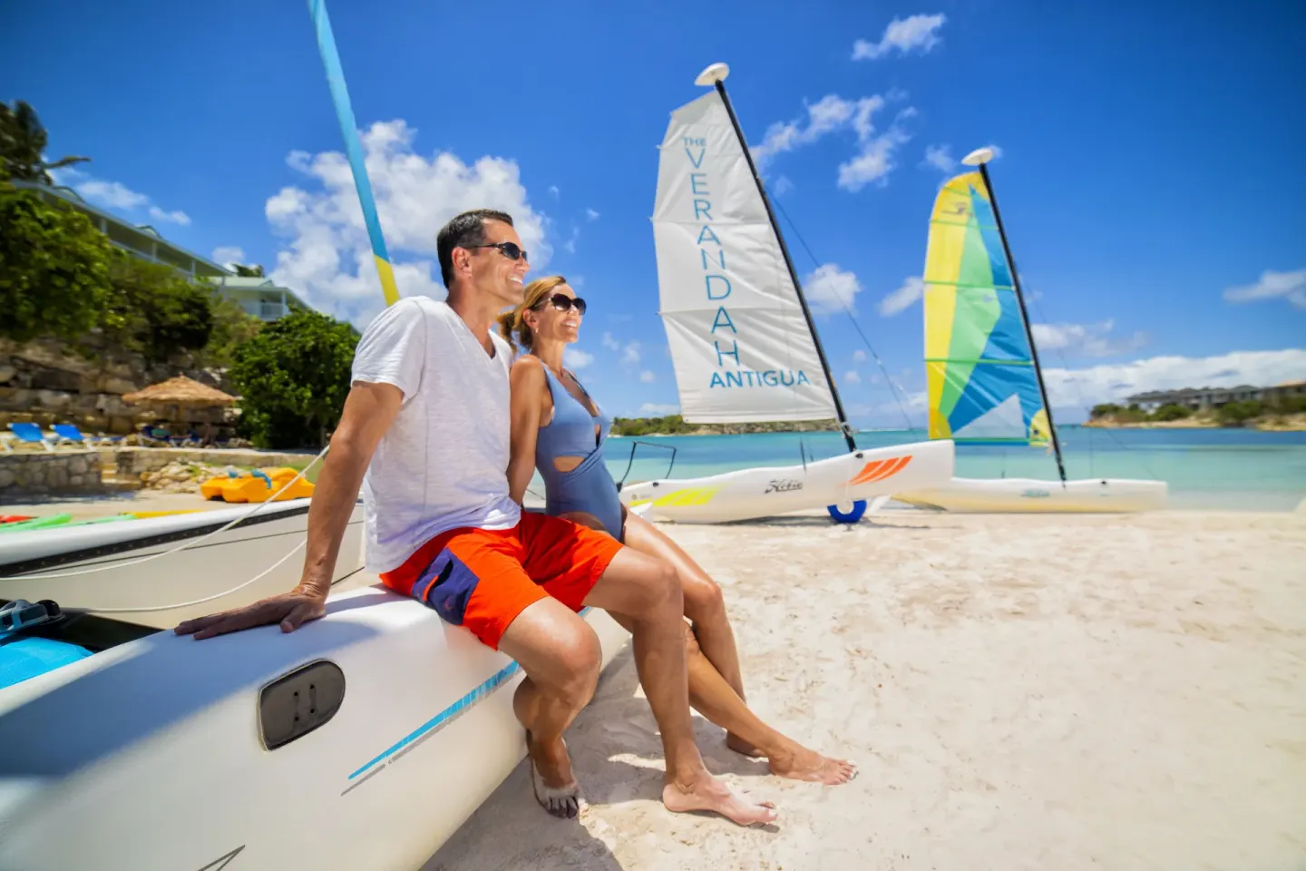 Couple sitting on a sailboat on the beach at The Verandah Antigua.