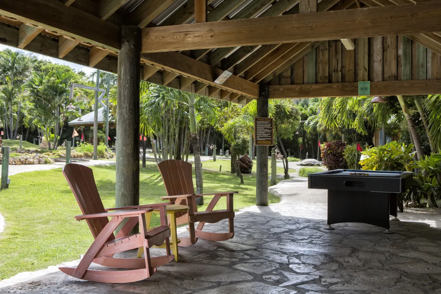 Covered game area with rocking chairs and a billiards table at The Verandah Antigua.