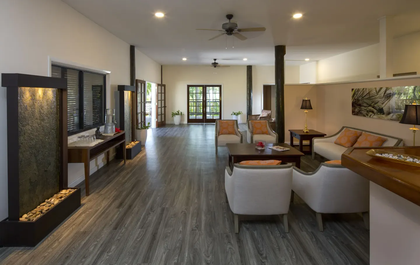 Spacious lobby lounge with seating, water features and wood floors at The Verandah Antigua.