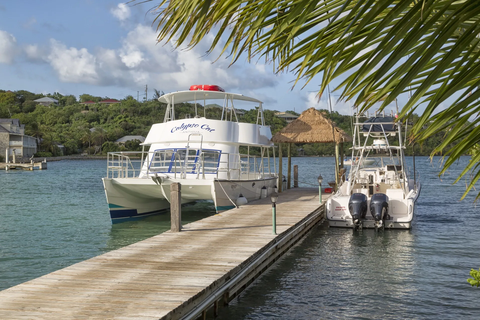 Boats moored beside a wooden dock at The Verandah Antigua.