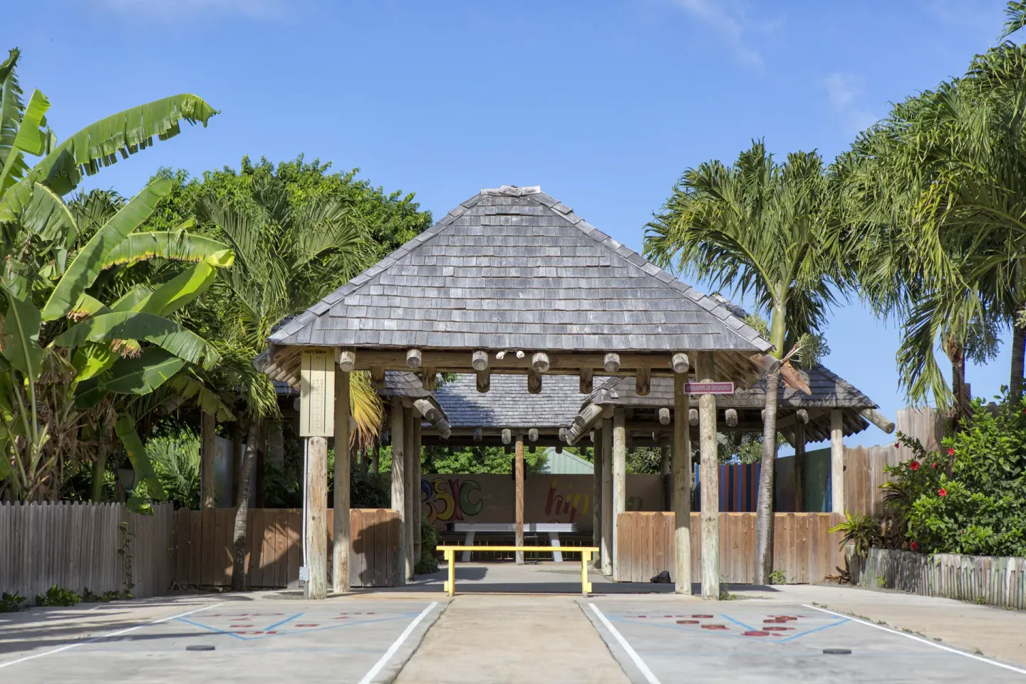 Shaded pavilion and outdoor game courts among palms at The Verandah Antigua.