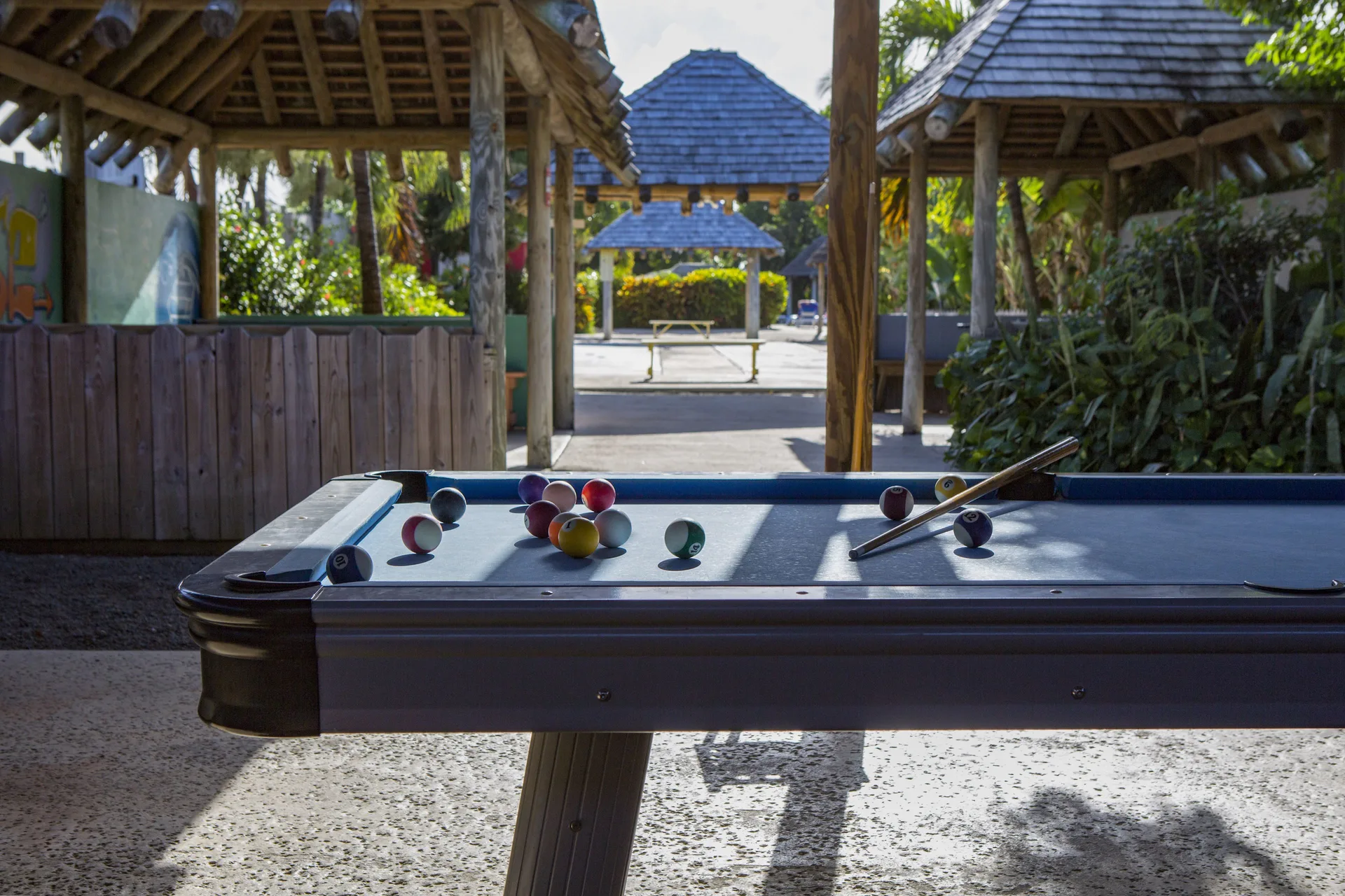 Pool table with balls and cue in a shaded games area at The Verandah Antigua.