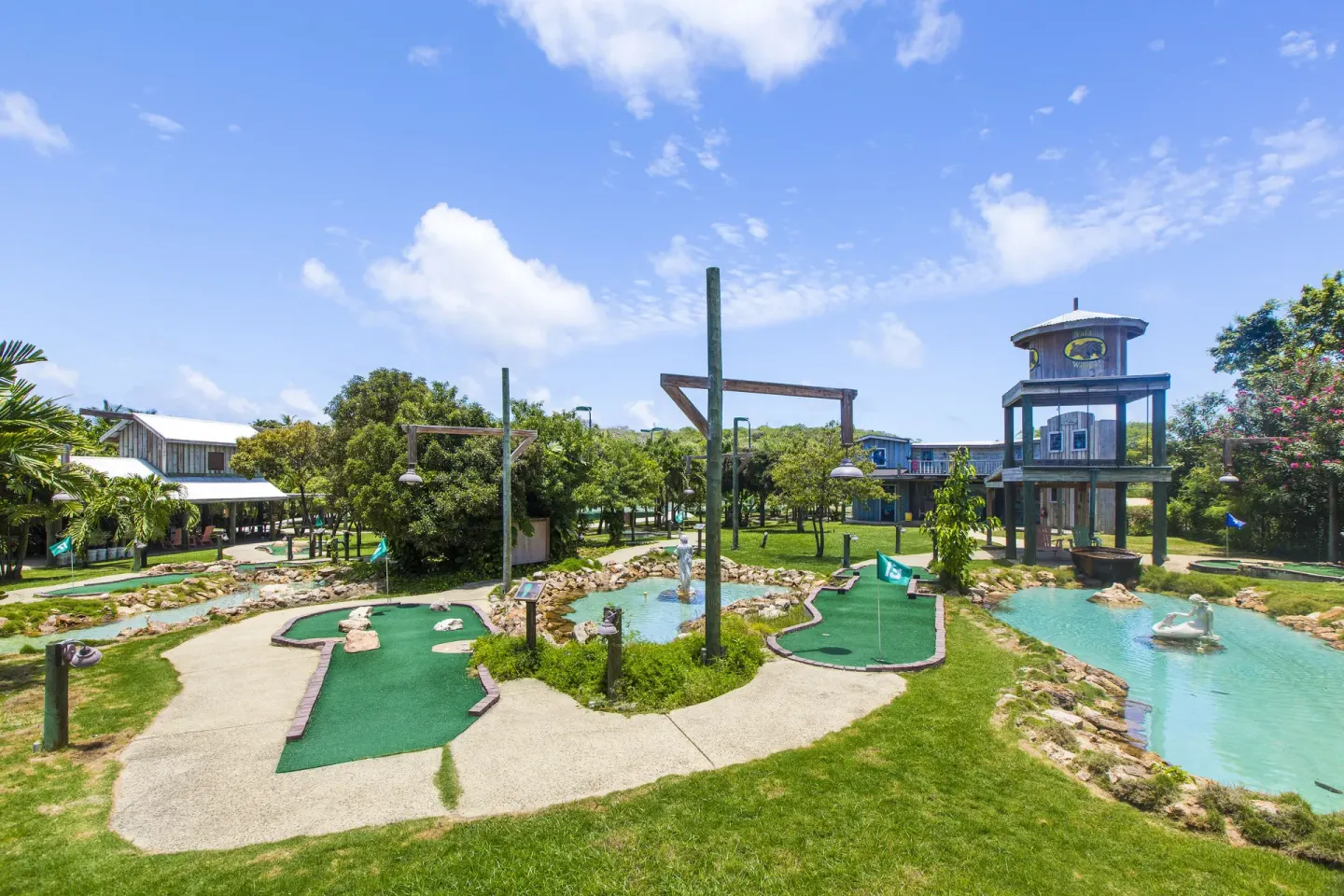 Mini golf greens and blue ponds beneath a bright sky at The Verandah Antigua.