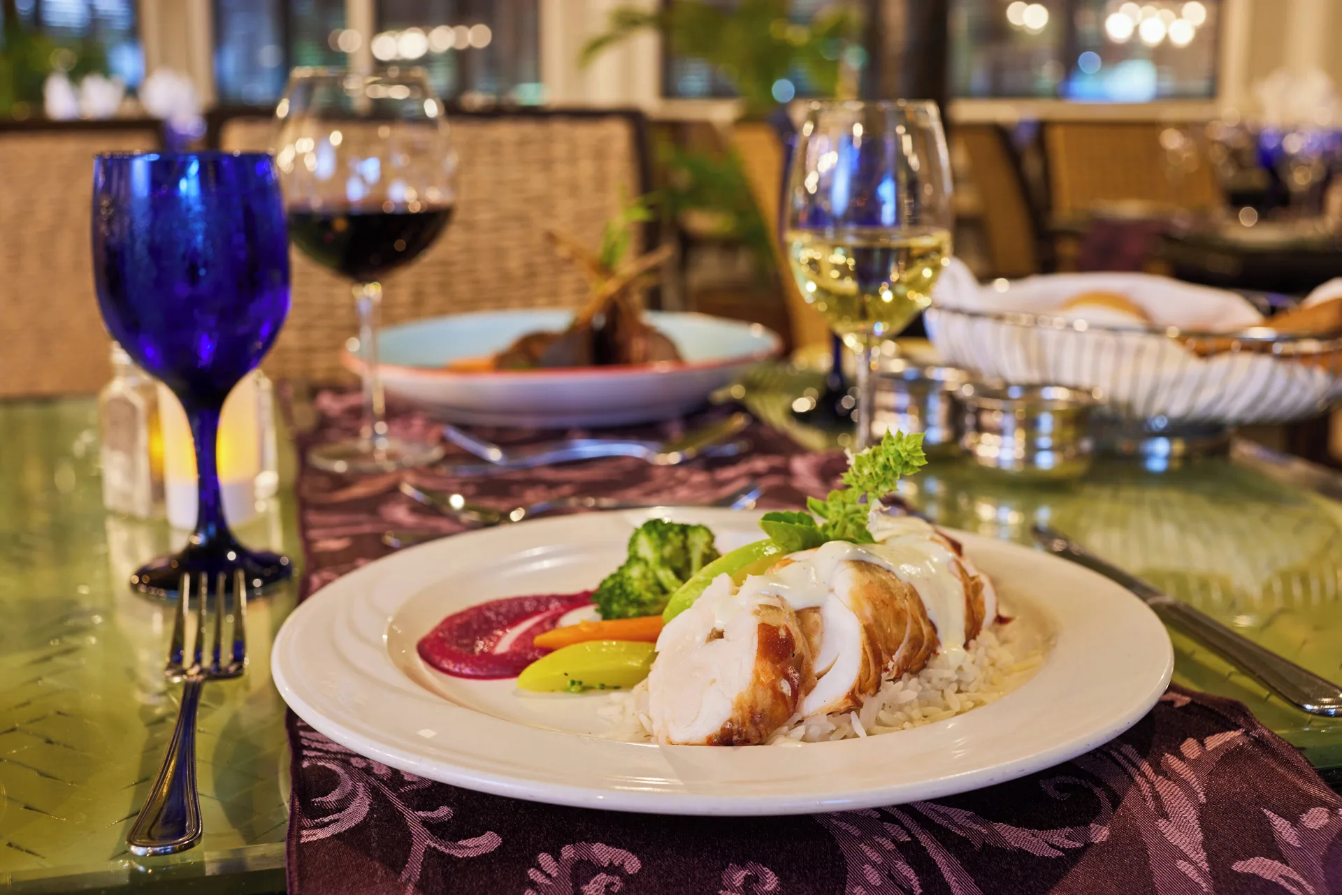 Plated dinner with wine glasses on a restaurant table at The Verandah Antigua.