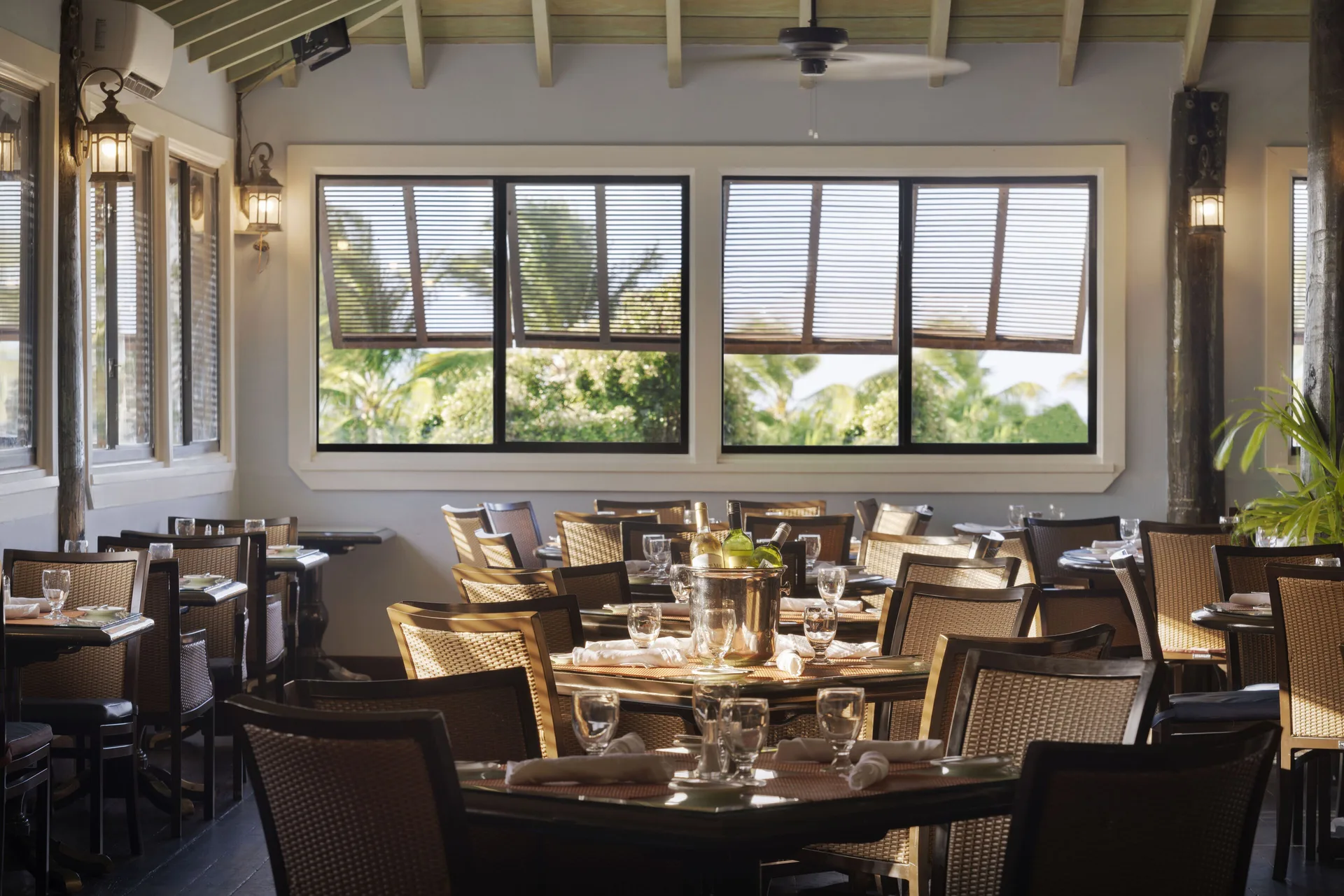 Set dining tables in a window-lined restaurant at The Verandah Antigua.
