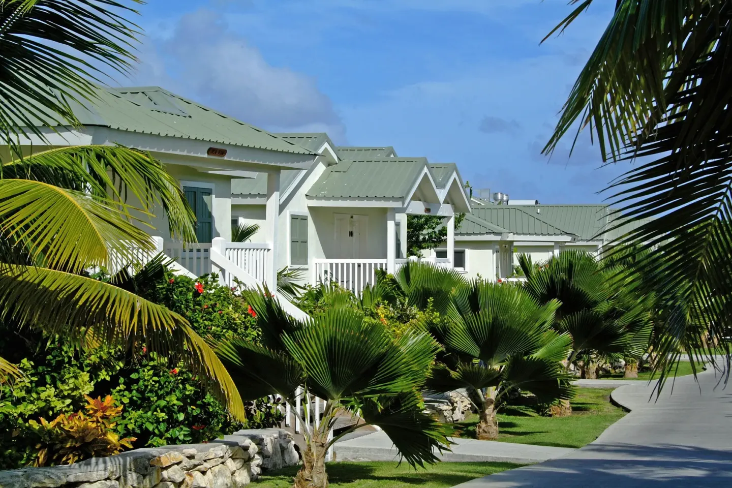 Hillside Suite cottages framed by palms at The Verandah Antigua.