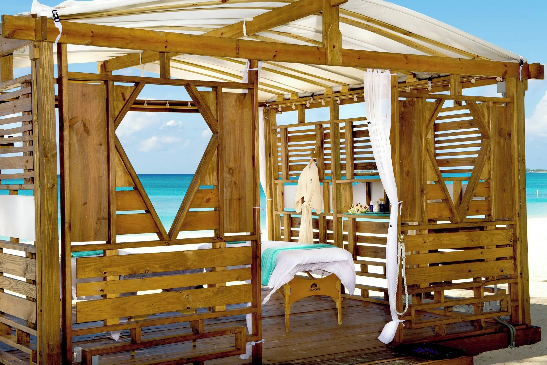Beachfront spa cabana with a massage table at The Westin Grand Cayman Seven Mile Beach Resort & Spa.
