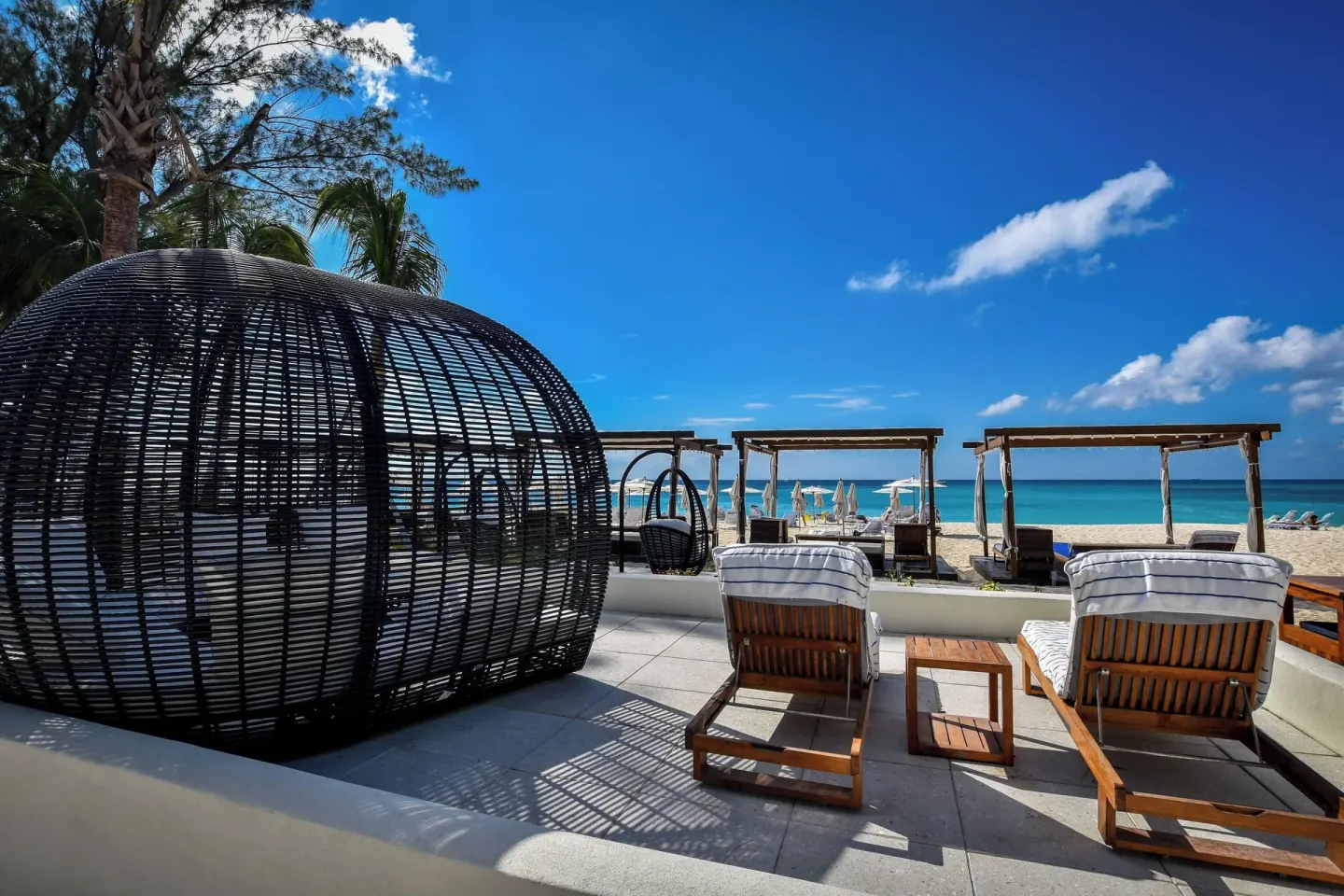Oceanfront lounge chairs and cabanas at The Westin Grand Cayman Seven Mile Beach Resort & Spa.