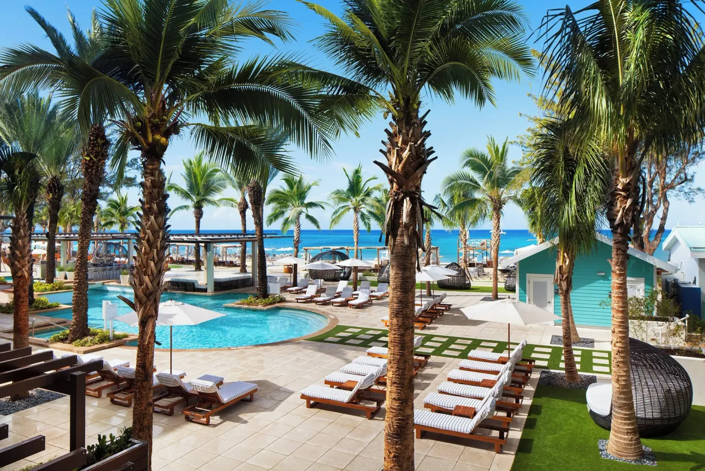 Palm-lined pool deck and ocean at The Westin Grand Cayman Seven Mile Beach Resort & Spa.