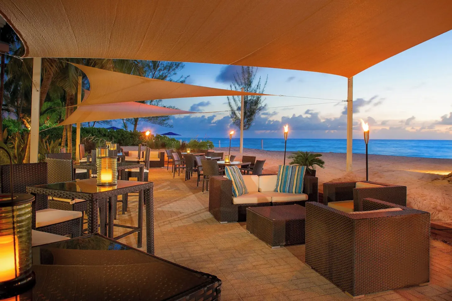 Beachfront lounge seating at The Westin Grand Cayman Seven Mile Beach Resort & Spa at dusk.