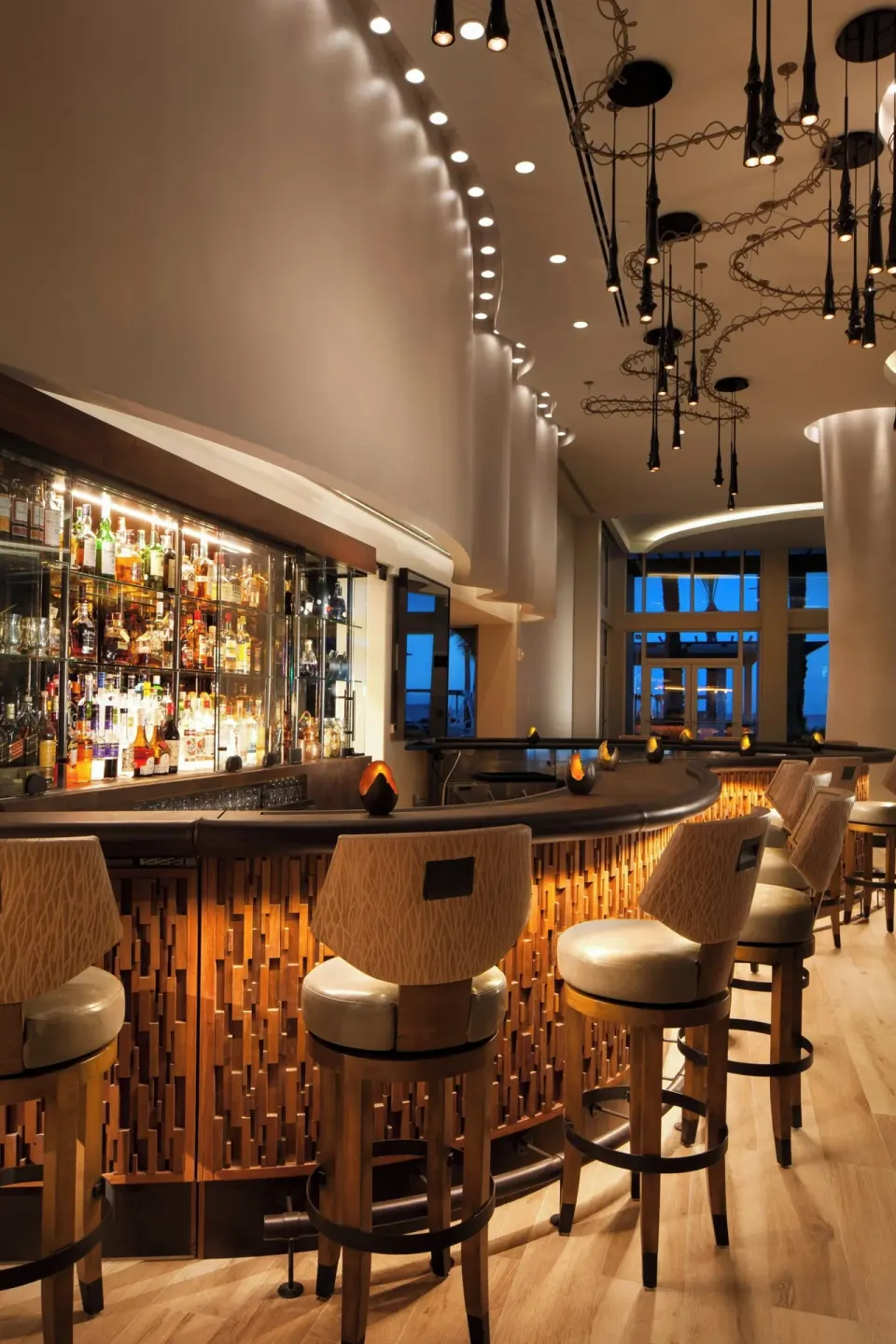 Curved indoor bar with stools at The Westin Grand Cayman Seven Mile Beach Resort & Spa.