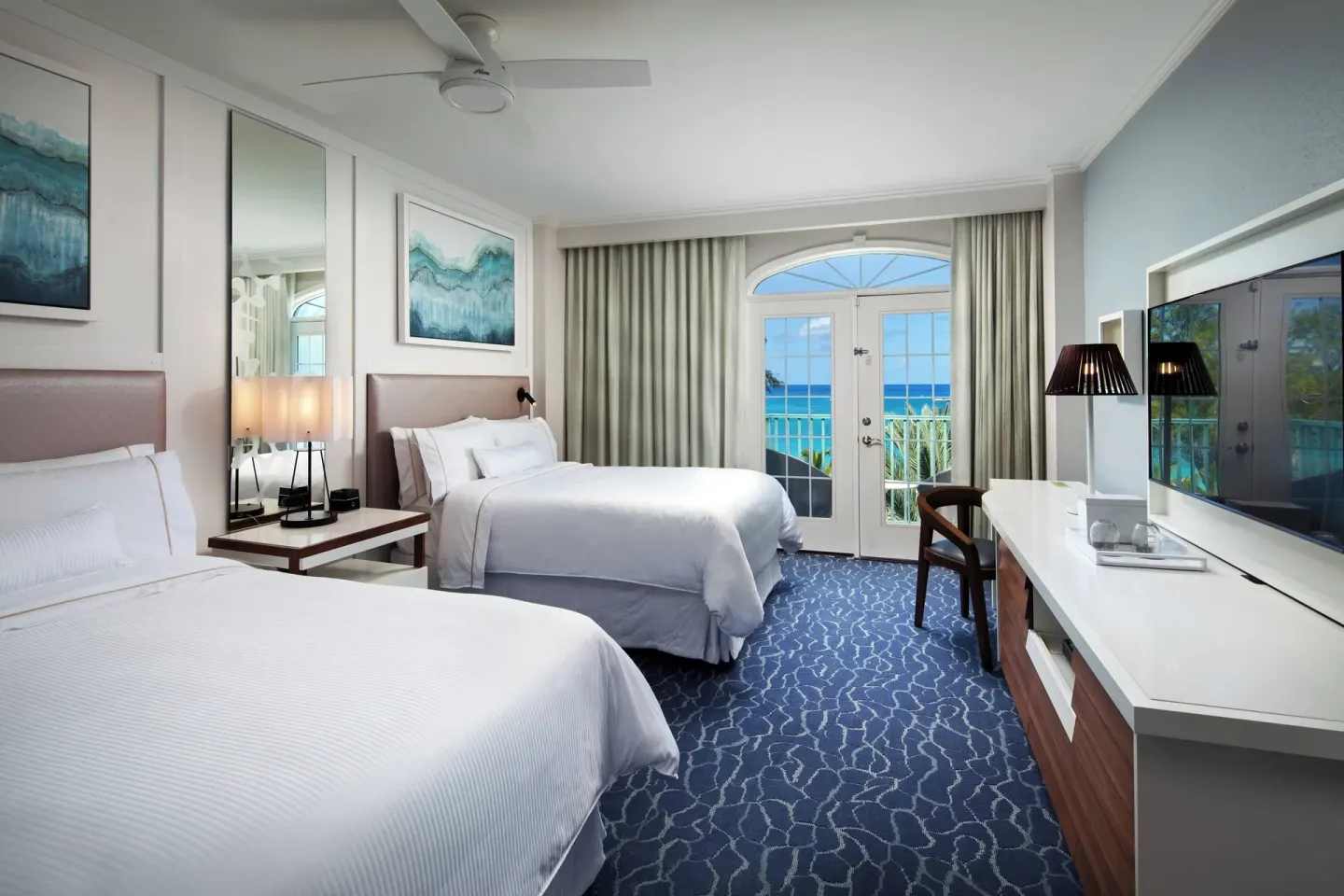 Two queen beds and balcony ocean view in a room at The Westin Grand Cayman Seven Mile Beach Resort & Spa.