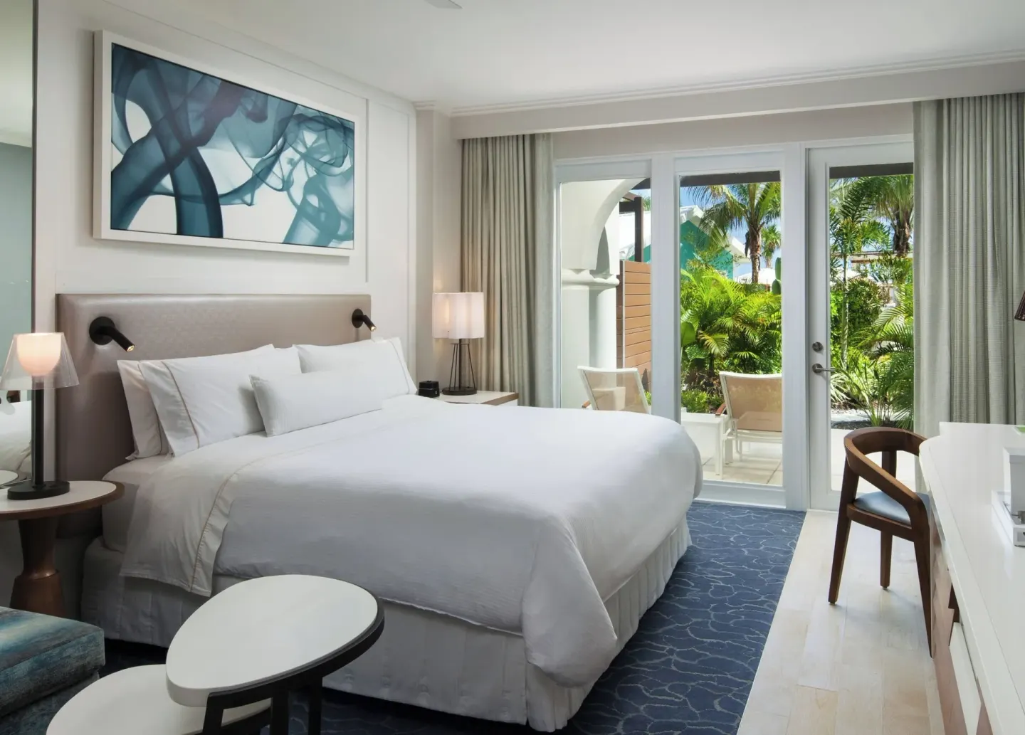 King bed and glass patio doors in a sofa bed room at The Westin Grand Cayman Seven Mile Beach Resort & Spa.