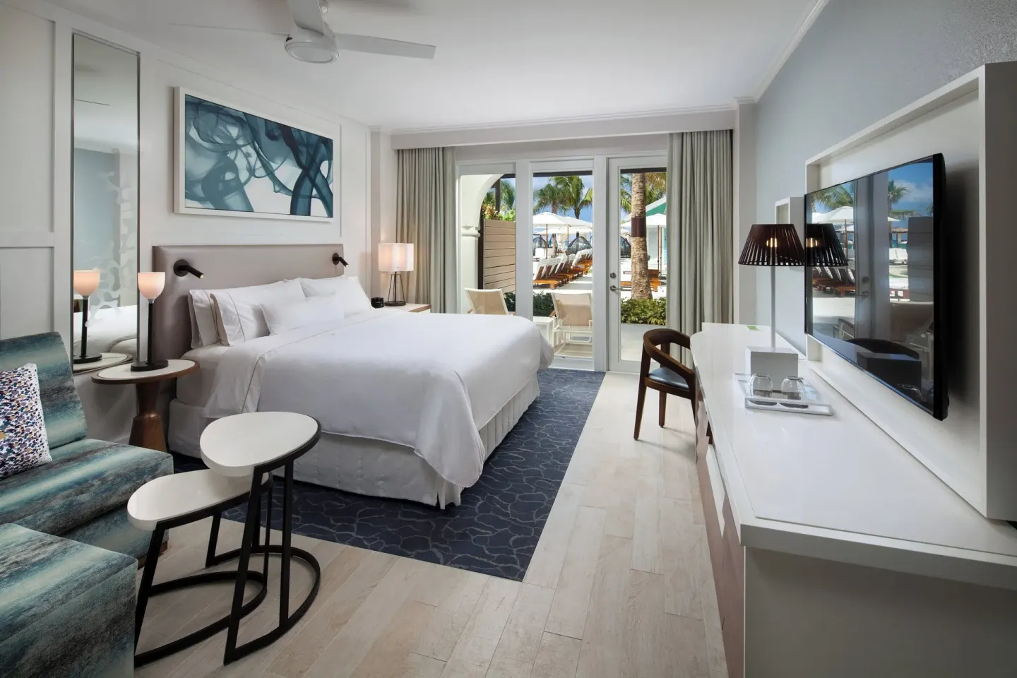 King room with sofa bed and patio view at The Westin Grand Cayman Seven Mile Beach Resort & Spa.