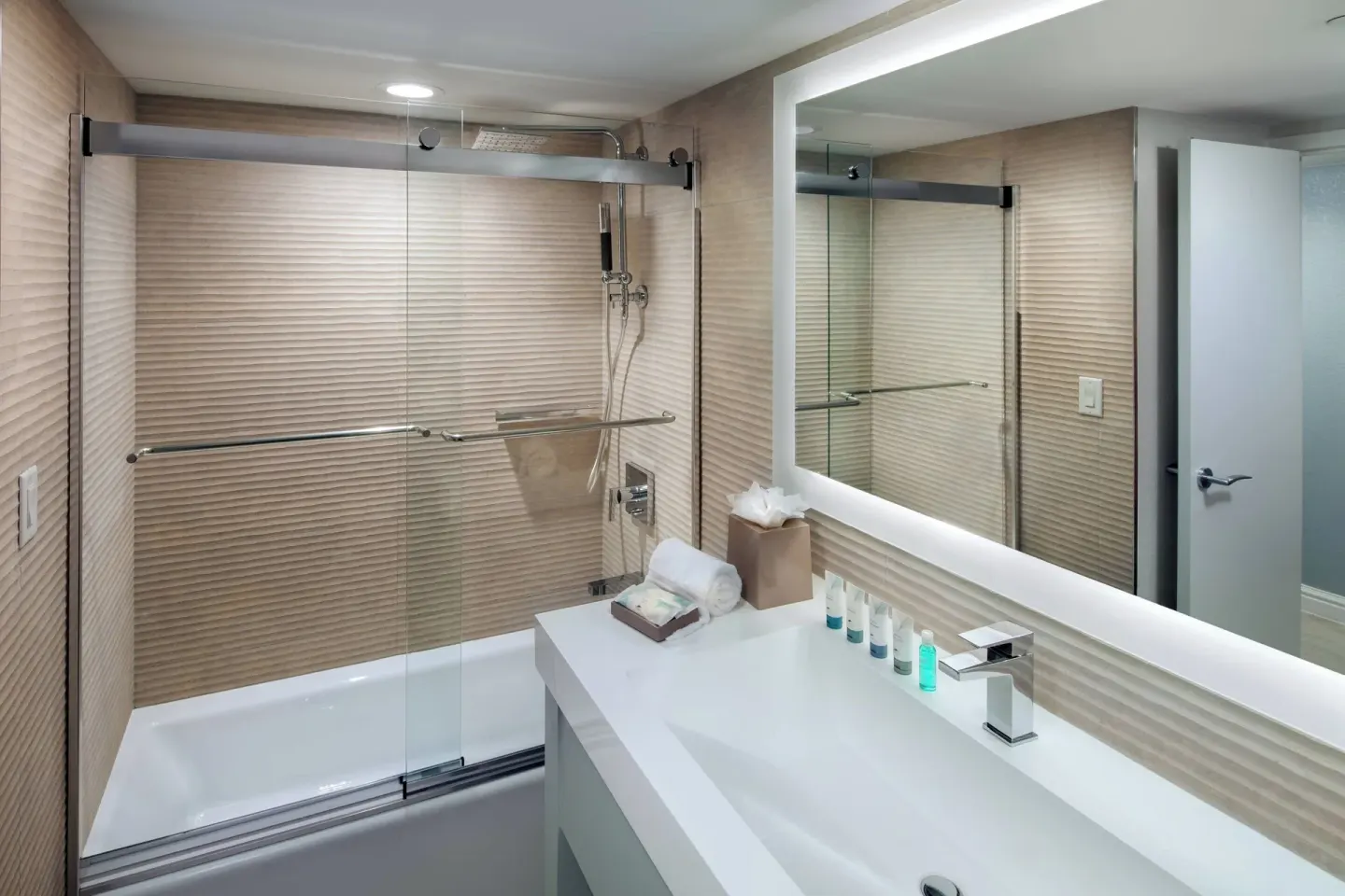 Guest room bathroom with glass shower and vanity at The Westin Grand Cayman Seven Mile Beach Resort & Spa.