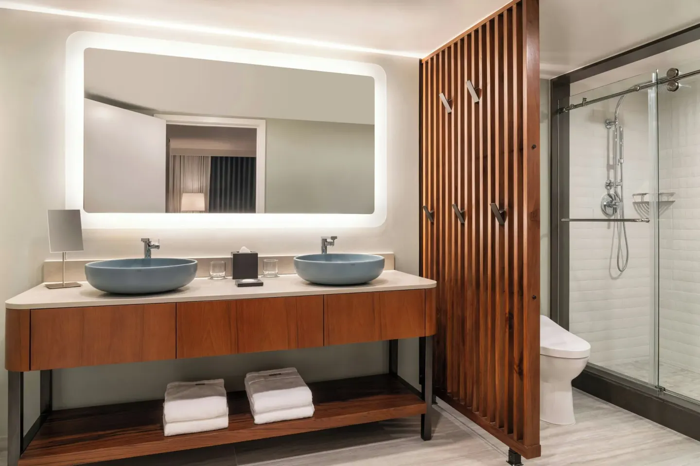 Guest bathroom with double blue sinks and glass shower at The Westin Maui Resort & Spa, Ka'anapali.