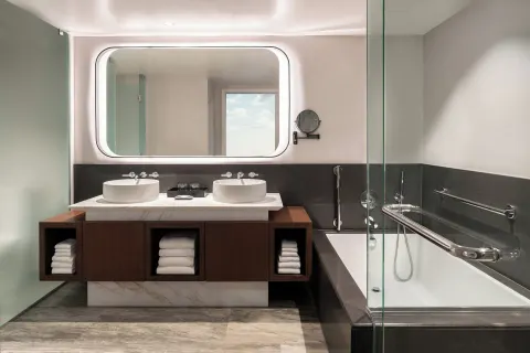 Guest bathroom with double vessel sinks and glass shower at The Westin Maui Resort & Spa, Ka'anapali.