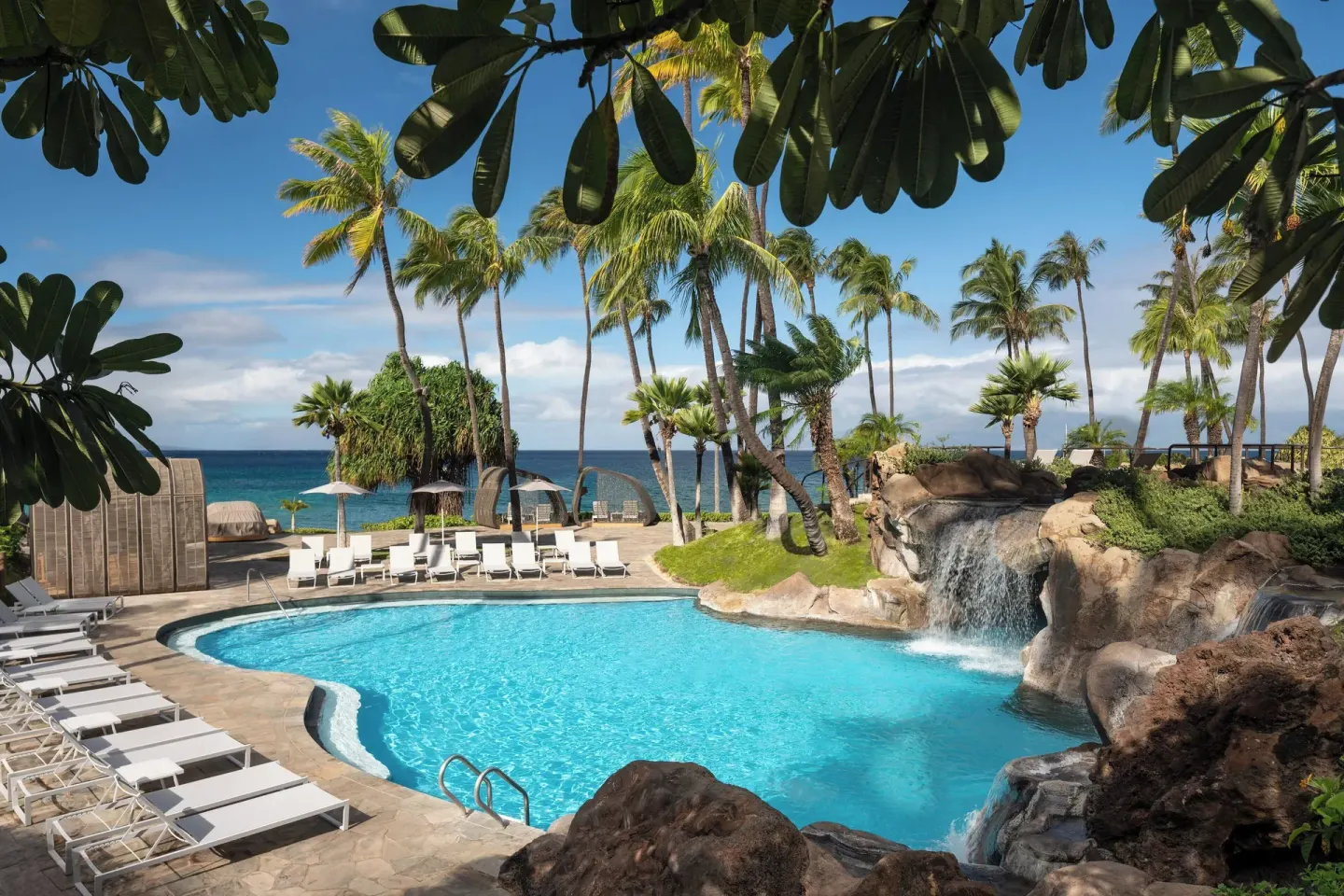 A pool with a rock waterfall and ocean backdrop at The Westin Maui Resort & Spa, Ka'anapali.