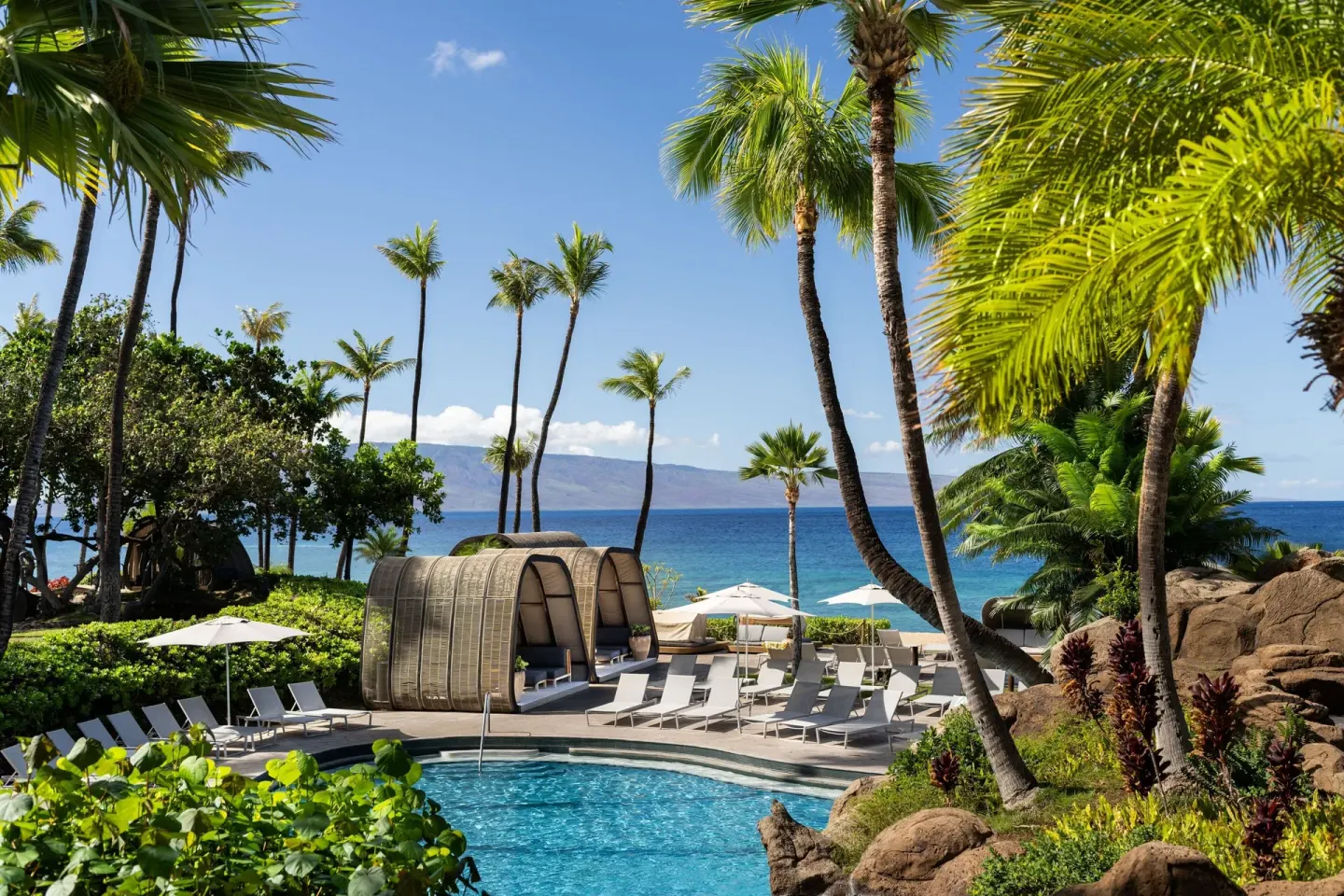 Poolside cabanas and palms face the ocean at The Westin Maui Resort & Spa, Ka'anapali.