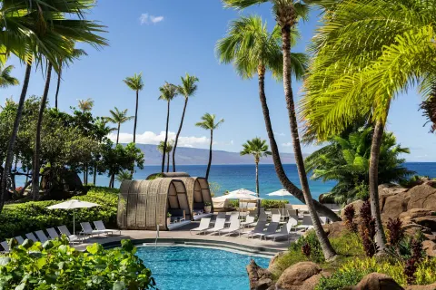 Poolside cabanas and palms face the ocean at The Westin Maui Resort & Spa, Ka'anapali.