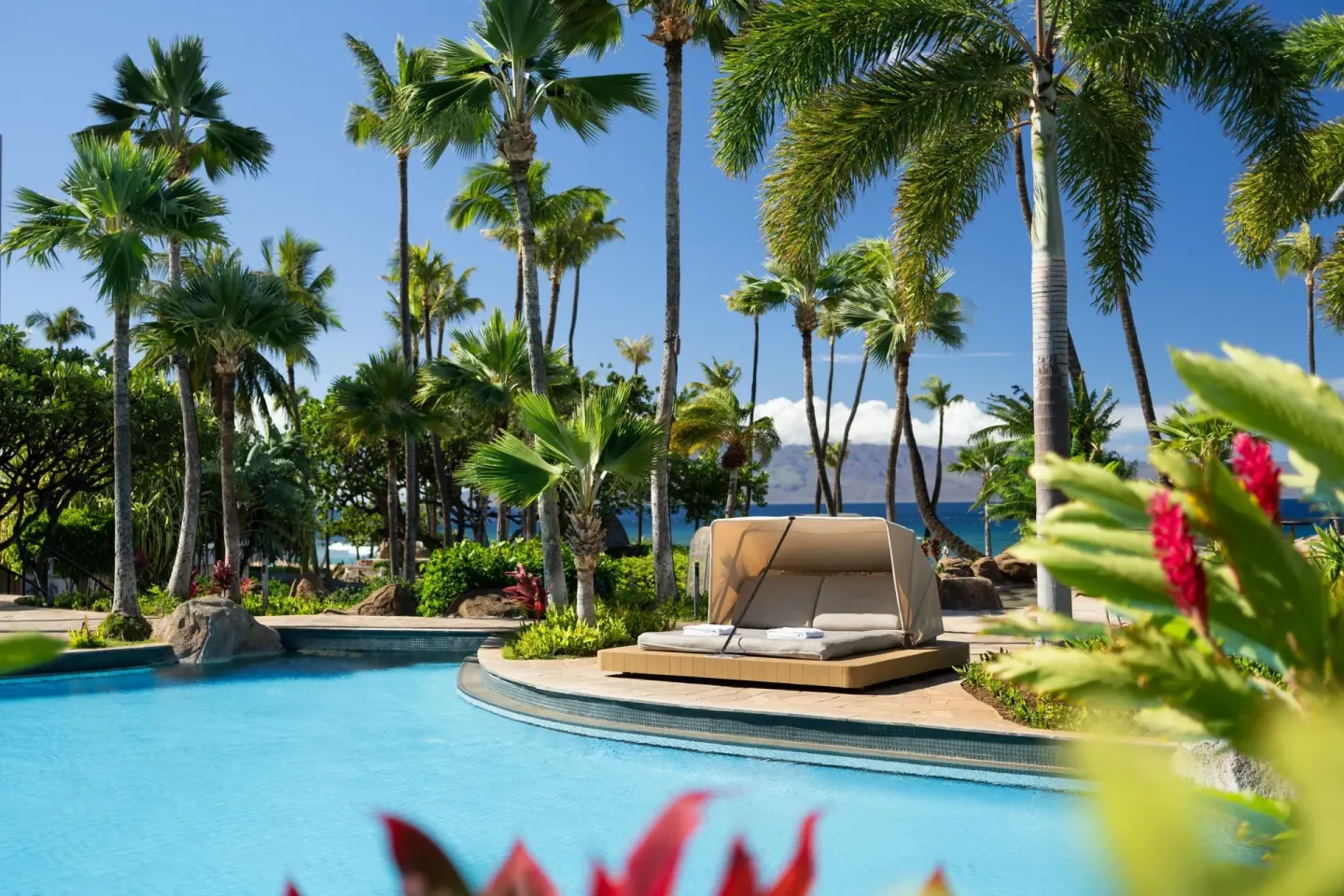 A daybed beside a palm-lined pool at The Westin Maui Resort & Spa, Ka'anapali.