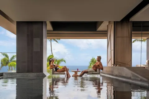 Guests sit in shallow spa water facing the ocean at The Westin Maui Resort & Spa, Ka'anapali.