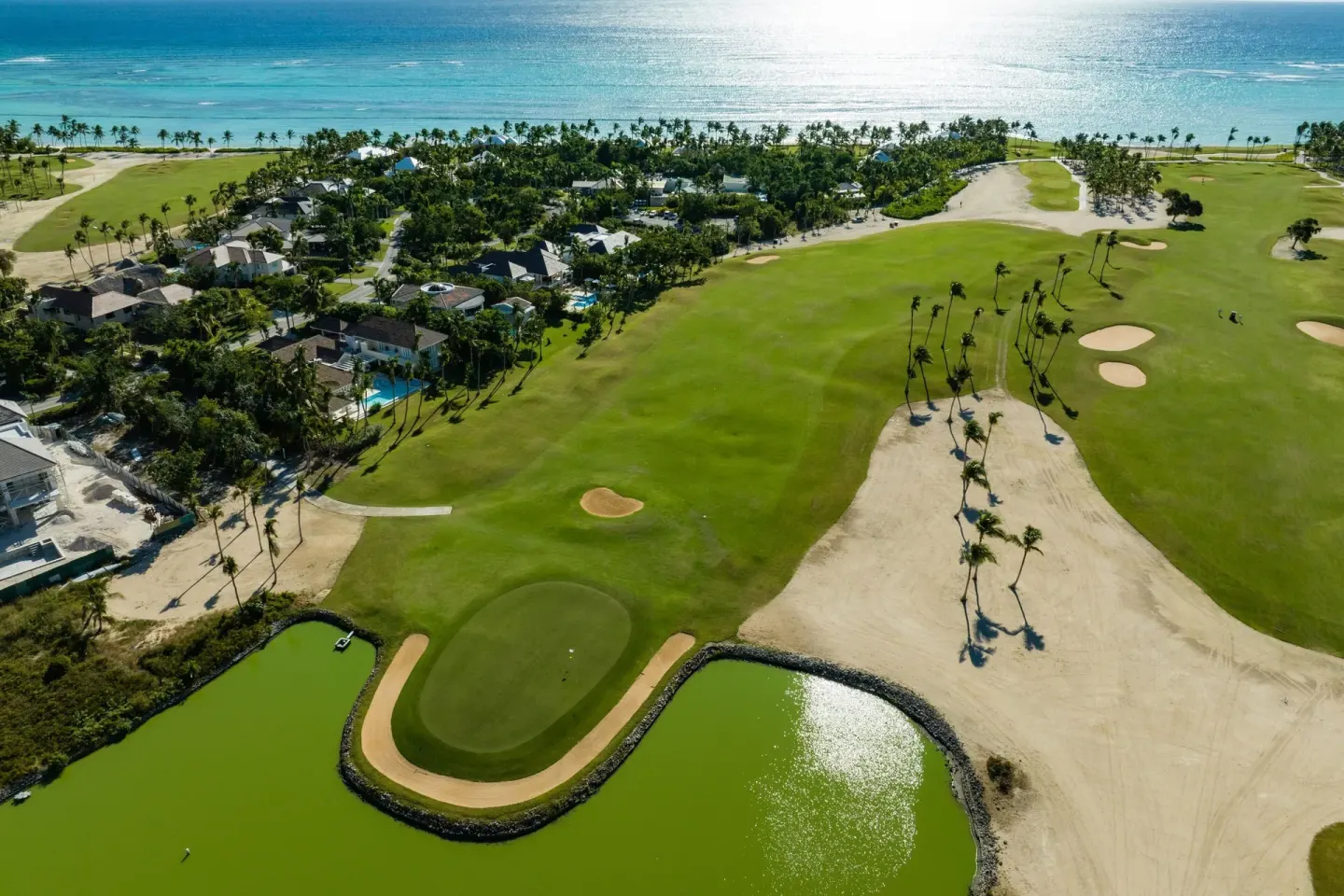 An aerial view shows golf greens, lagoons, palms, and the ocean at The Westin Puntacana Resort.